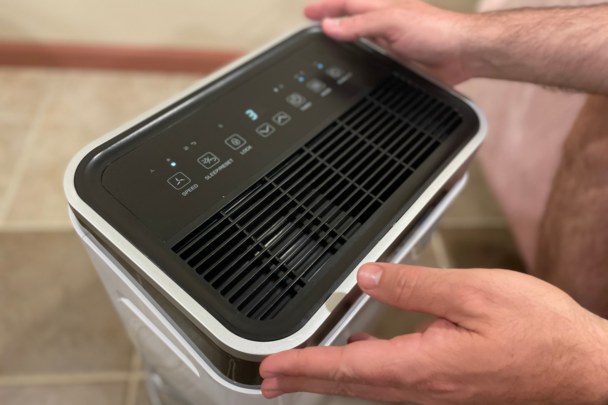 hands setting up controls of dehumidifier