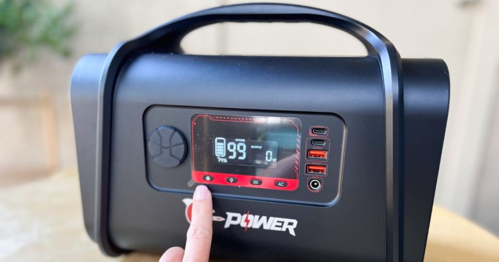 person pointing to digital display on G-Power portable power station and generator