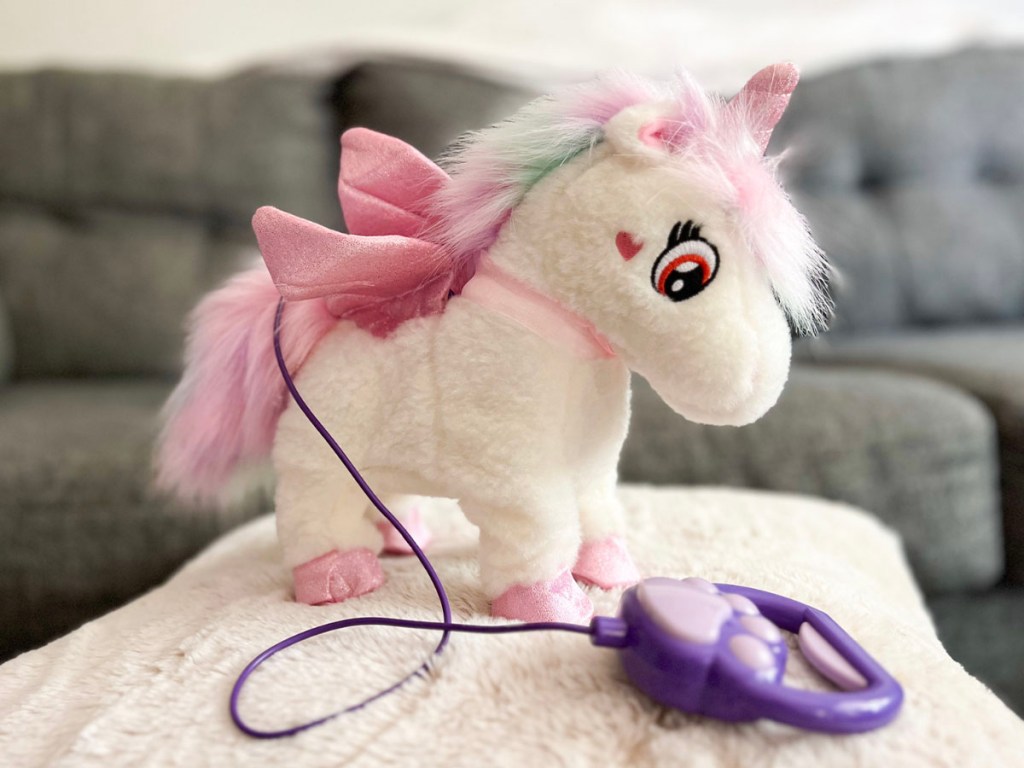 white and pink unicorn toy with purple remote
