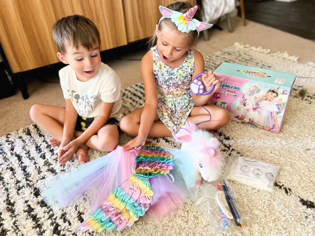 two kids playing with unicorn toy set 