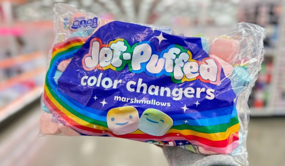a woman's hand displaying a bag of color changing jet-puffed marshmallows