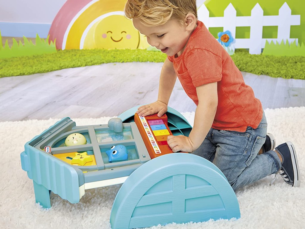 kid playing with Little Tikes Learn & Play Look & Learn Window laying down