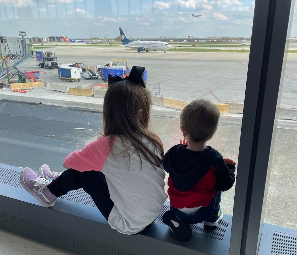 two kids sitting at airport 