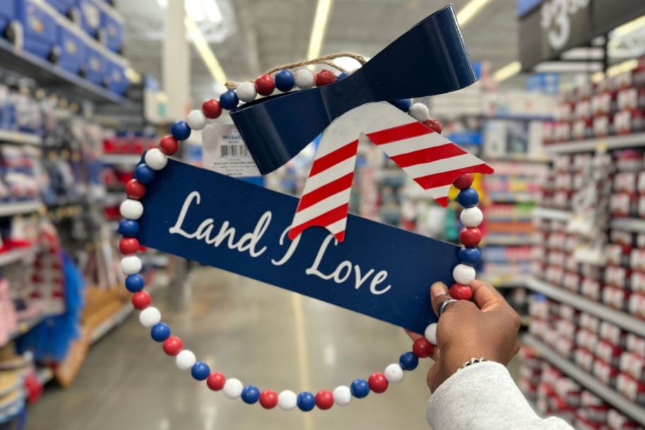 womans hand holding up a patriotic land i love wearth