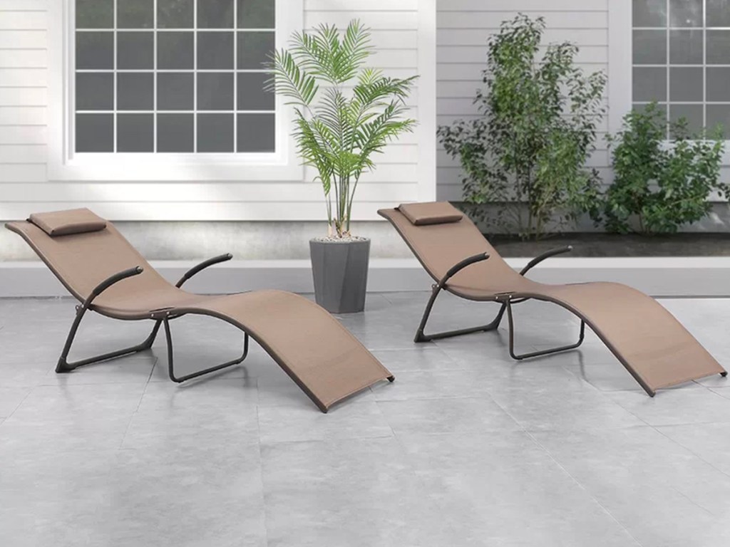 two tan chaise lounge chairs sitting on porch