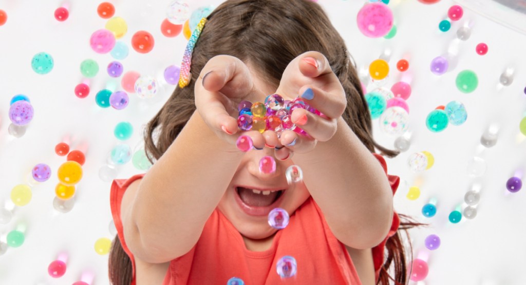 little girl playing with orbeez water beads