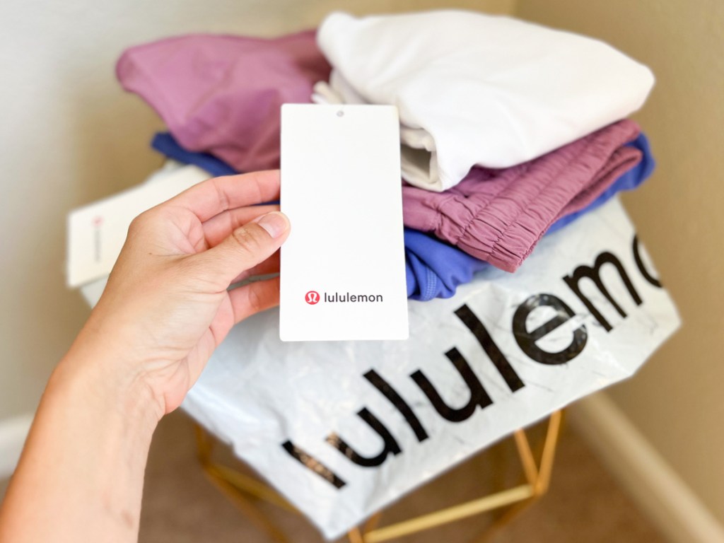 hand holding lululemon tag from a pile of clothes
