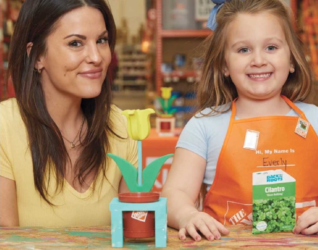 smiling mom and daughter at a home depot kids clinic making a planter and holding seeds