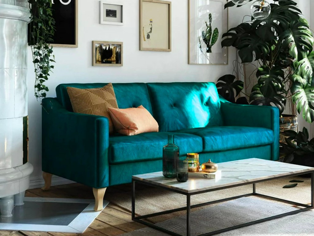 teal couch with orange pillow 