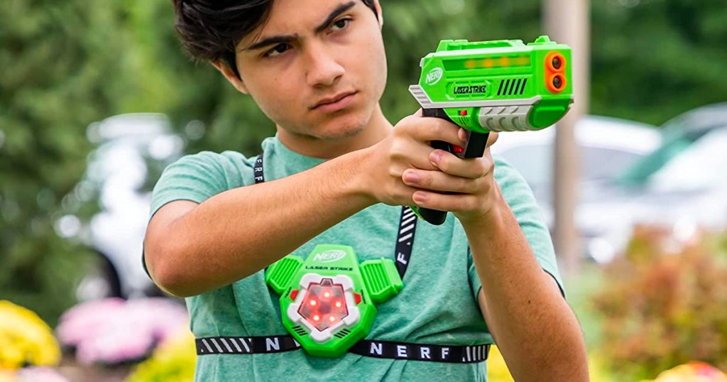 boy in green shirt using nerf lazer tag gun