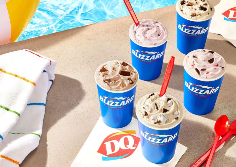 dairy queen blizzard ice cream treats next to a pool with red spoons