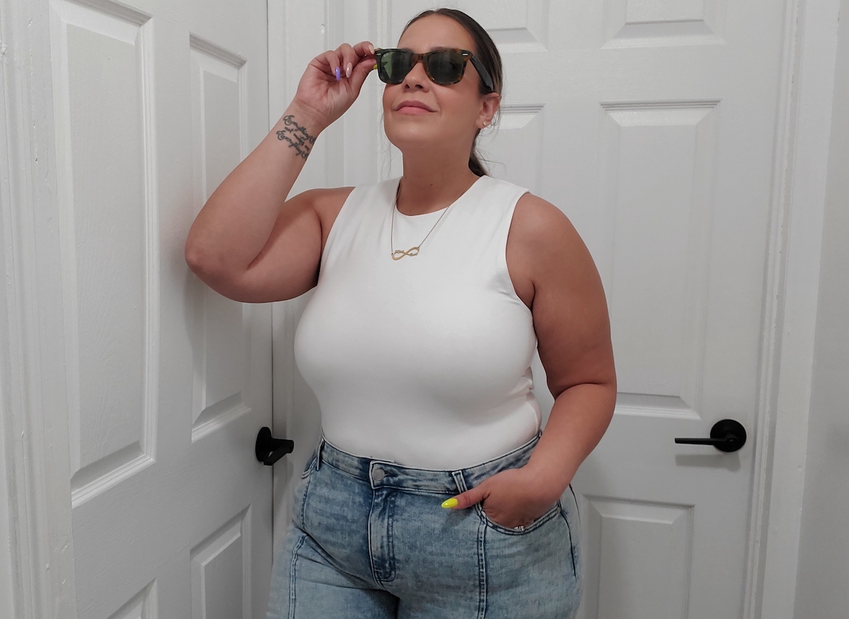 woman posing in white tank bodysuit wearing sunglasses
