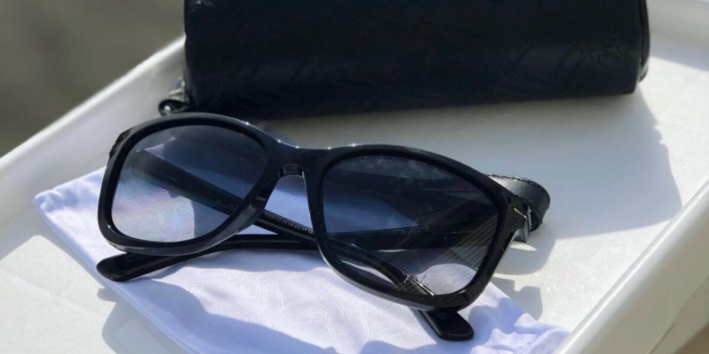 Schwarz gerahmte Oakley-Sonnenbrille auf weißem Etui mit schwarzem Gehäuse dahinter