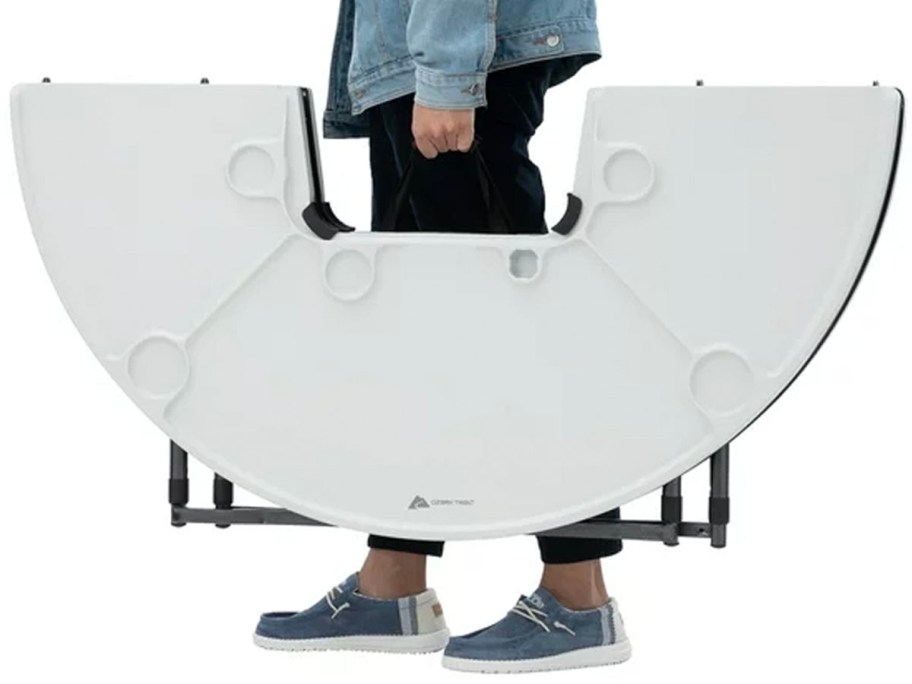 person carrying folding camping table