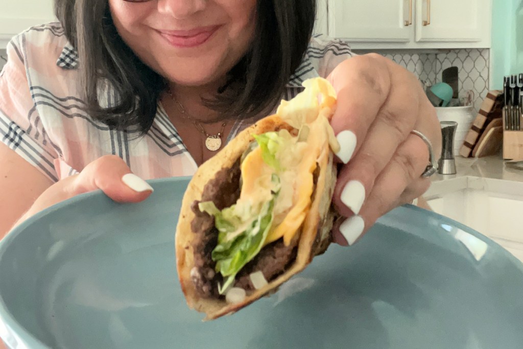 person holding a smash burger taco