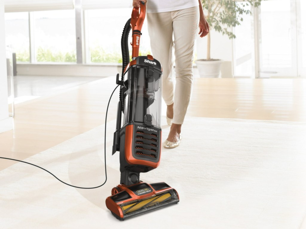 person using Shark Navigator Self-Cleaning Brushroll Pet Upright Vacuum on wood floor