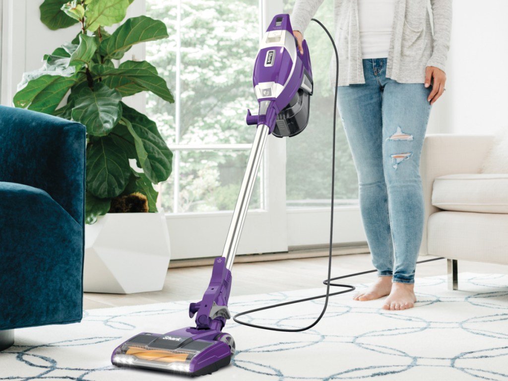 person using Shark Rocket Pet Pro Corded Stick Vacuum Cleaner w_ Self-Cleaning Brushroll om the rug