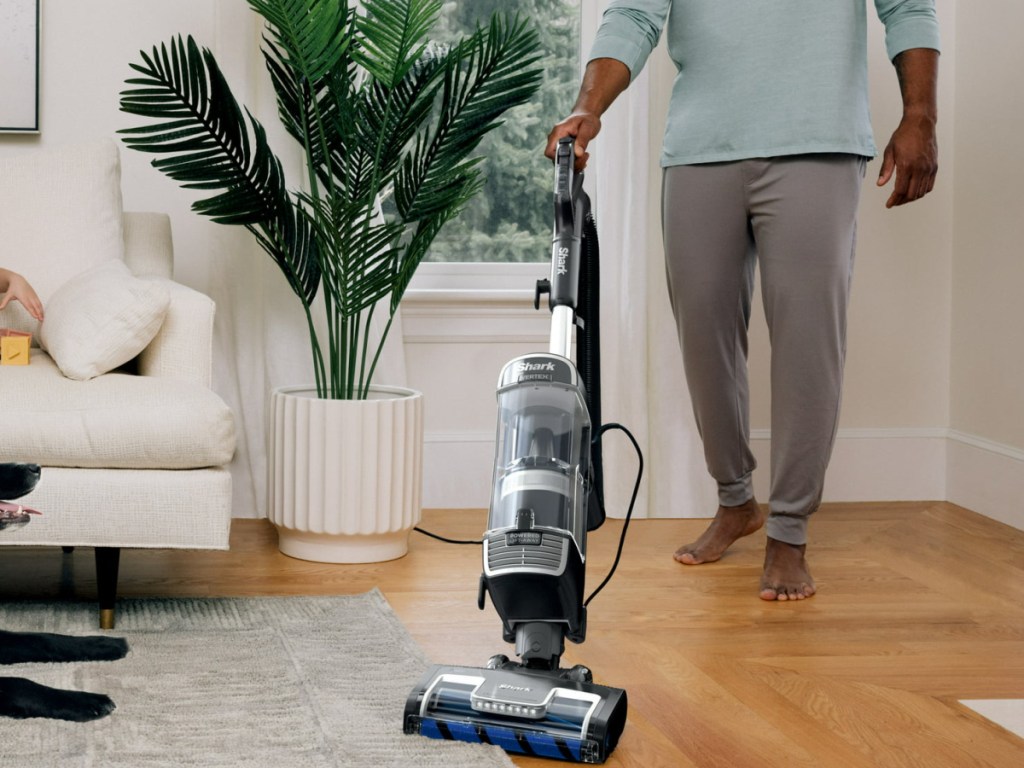 person using The Shark Vertex Speed Upright Vacuum w_ DuoClean PowerFins through his hardwood and rug
