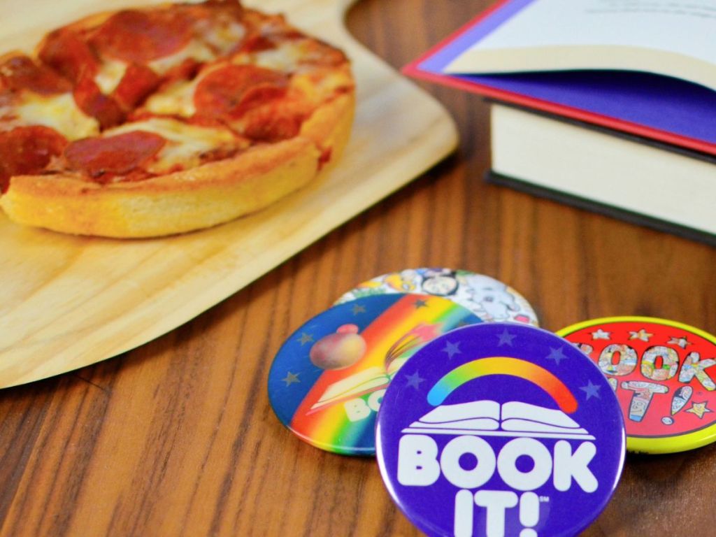 personal pan pizza on table near book and reading pins