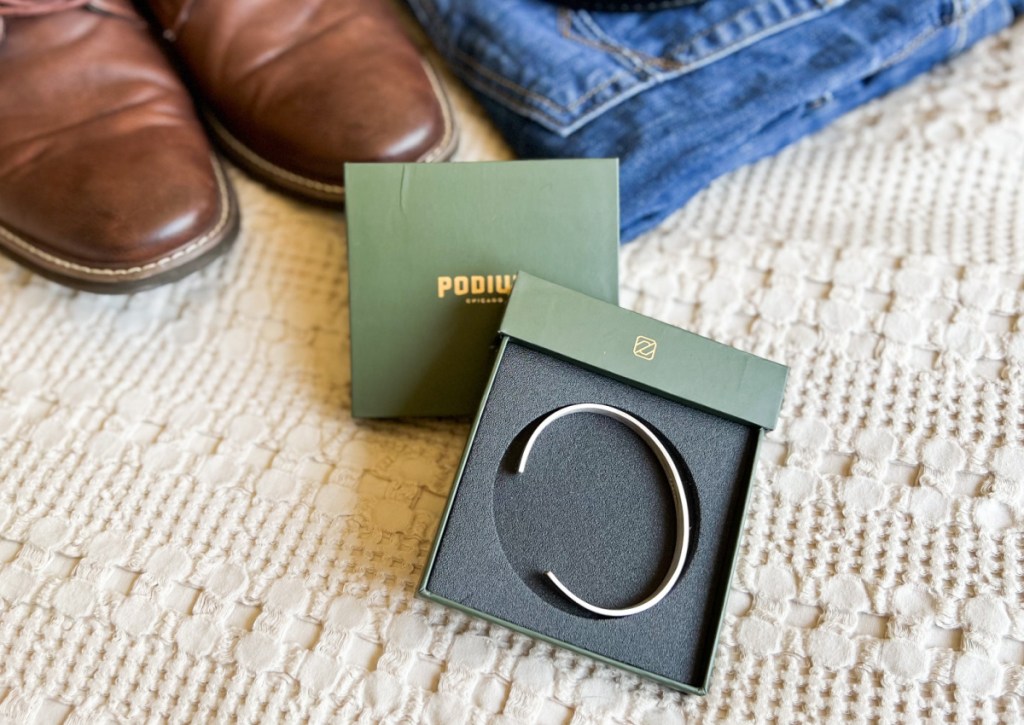 siver cuff bracelet in box next to mens shoes and jeans