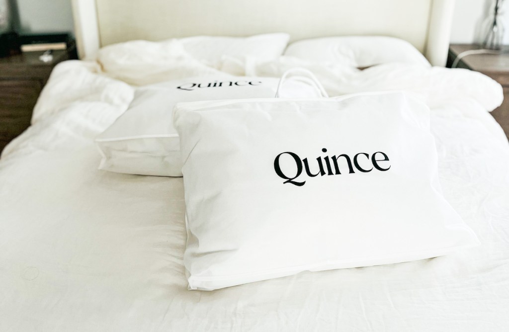two quince pillows in bags on bed