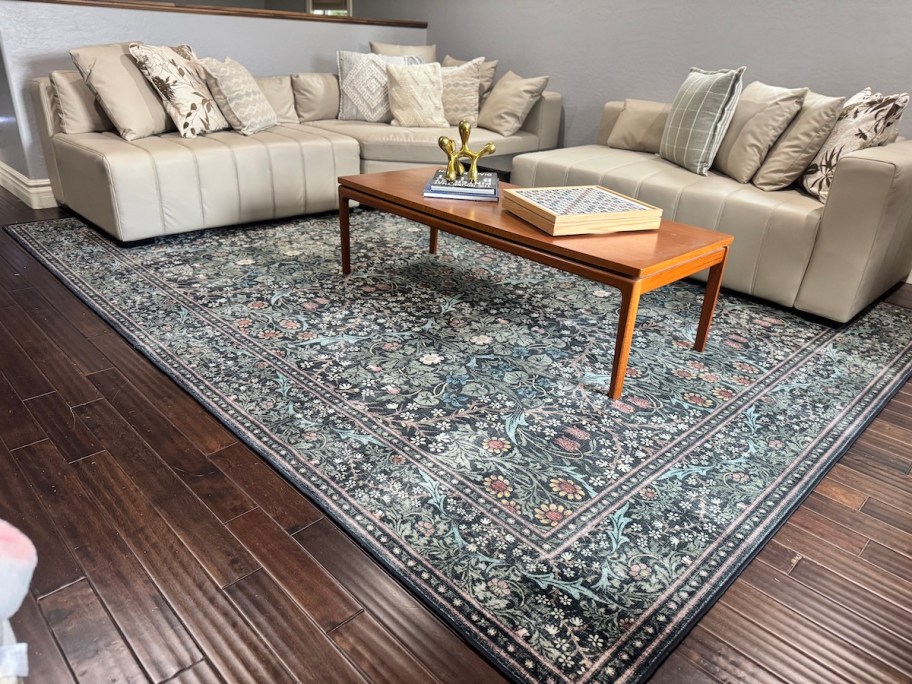 green floral rug in living room with beige sectional 