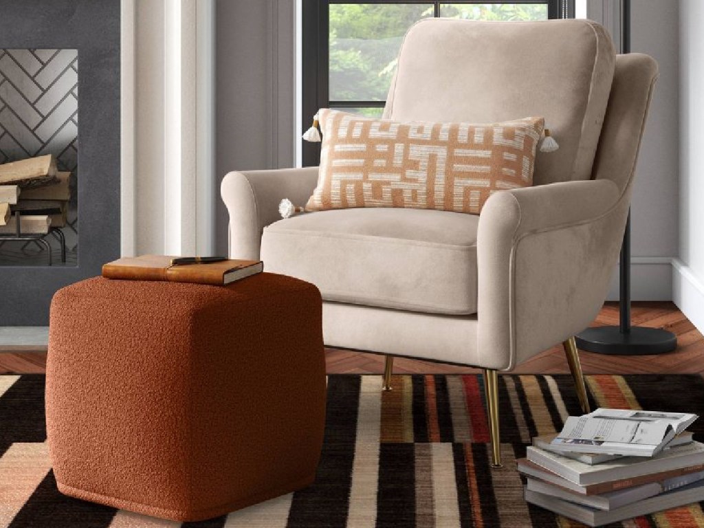 rustic ottoman displayed next to beige chair and magazines on the floor