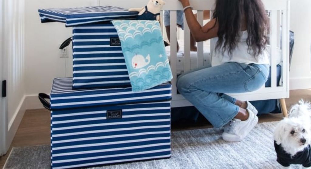 blue and white striped storage bins stacked on floor by baby crib