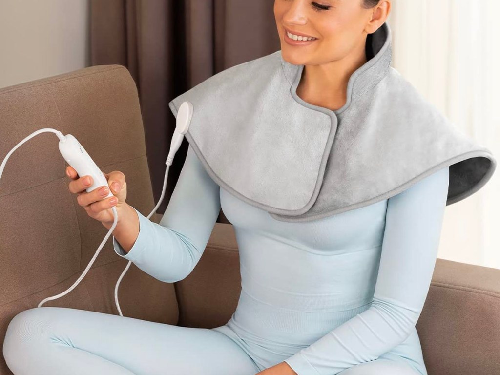woman wearing gray heating pad on shoulders 