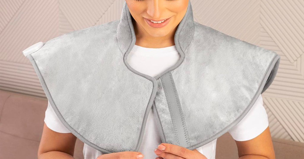 woman wearing gray heating pad on shoulders 