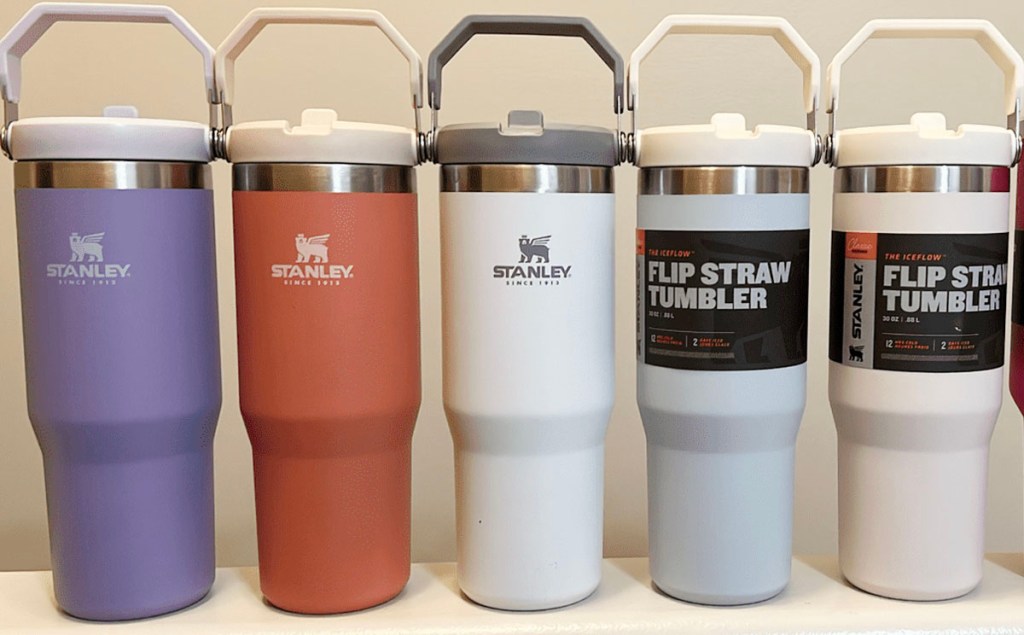 5 stanley flip straw tumblers in multiple colors in a row on counter 