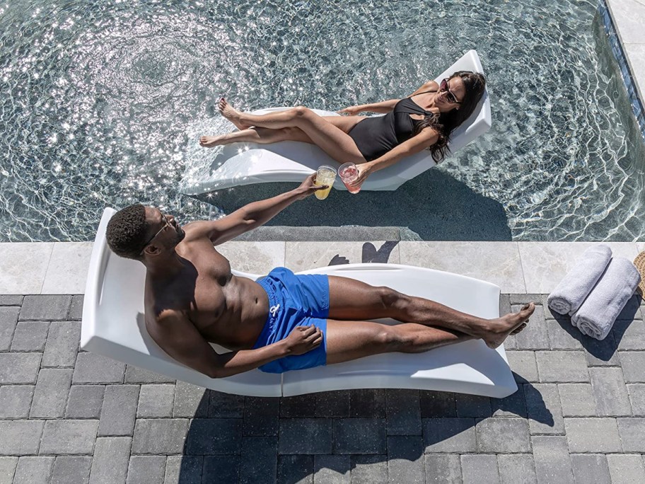 man and woman in a vero pool lounger, one in and one out of the pool