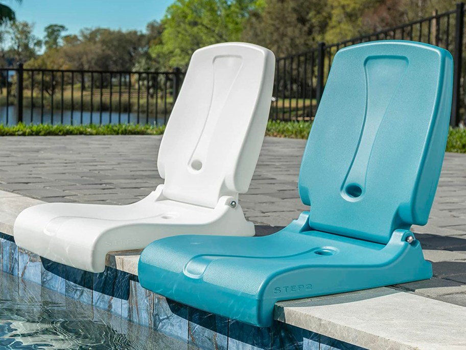 two flip seats in white and teal sitting on ledge of pool