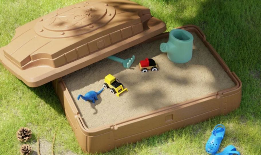 a kids sandbox filled with sand and toys.