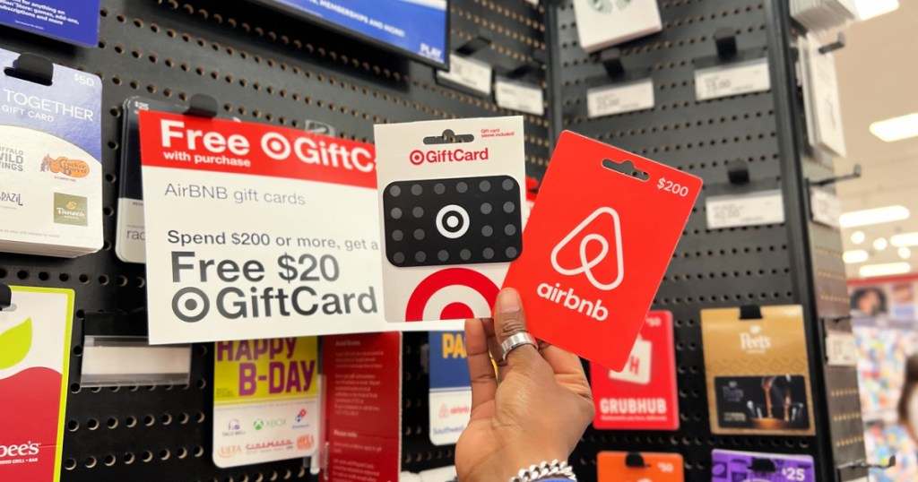 person holding target and airbnb gift cards