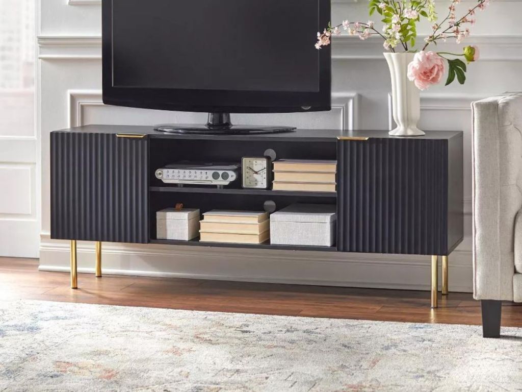black and gold TV stand with TV on it