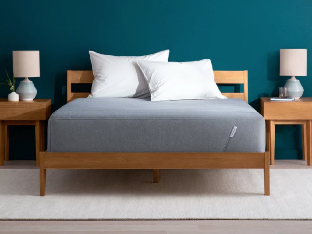 hybrid mattress on wood bed frame with white pillows