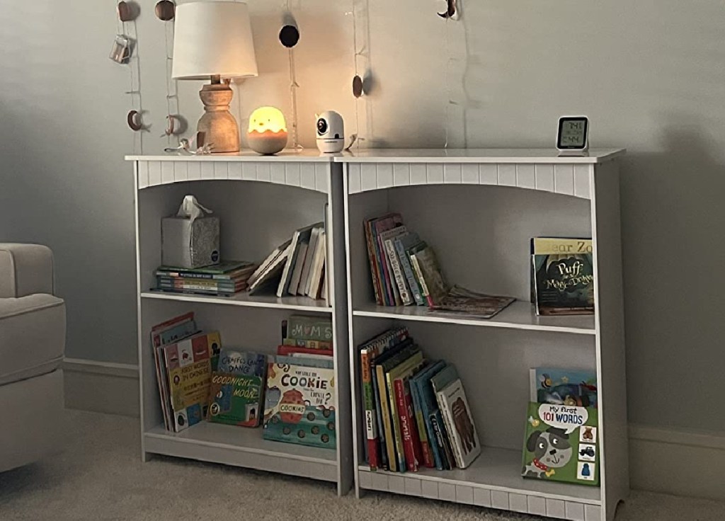 two bookshelves in nursery with books and trinkets inside