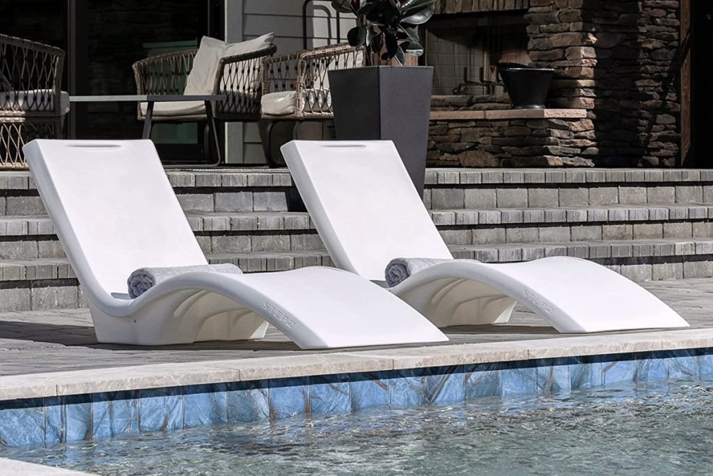 two white vero pool loungers side by side next to the edge of a pool