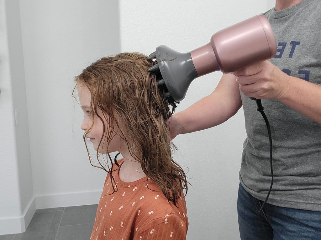 woman using pink wavytalk diffuser on childs hair
