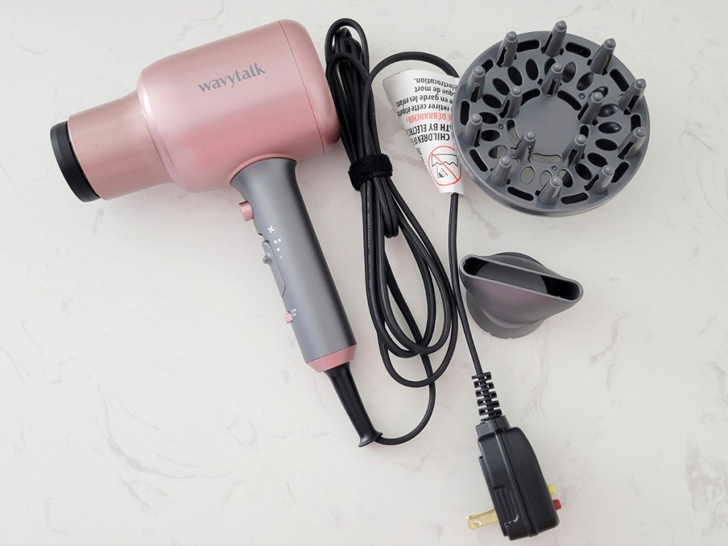 pink wavytalk hair dryer with diffuser attachments laying on counter