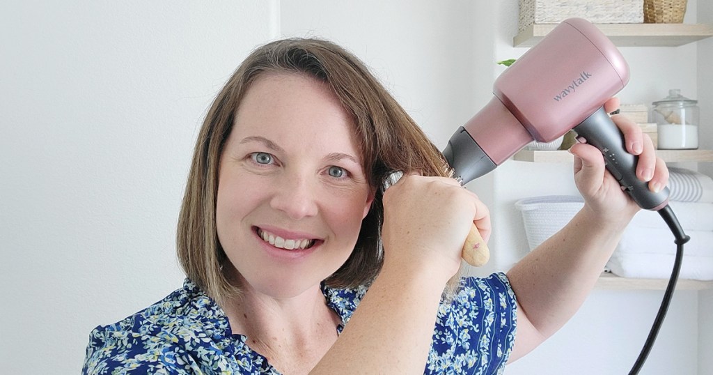 woman using pink wavytalk hair dryer on hair