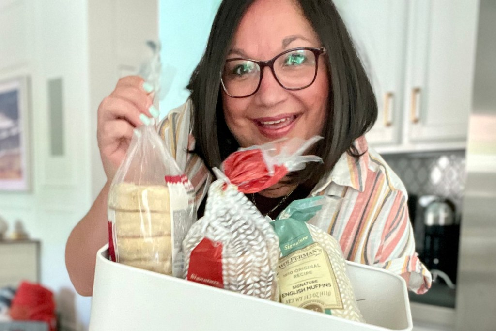 woman pulling english muffins bag out of tin