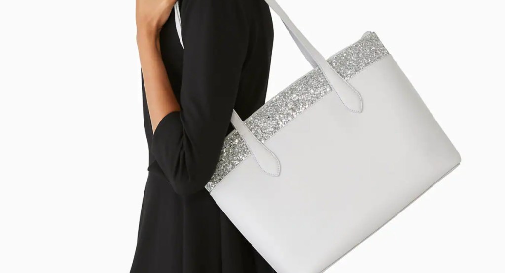 woman holding Kate Spade Flash Glitter Tote in gray