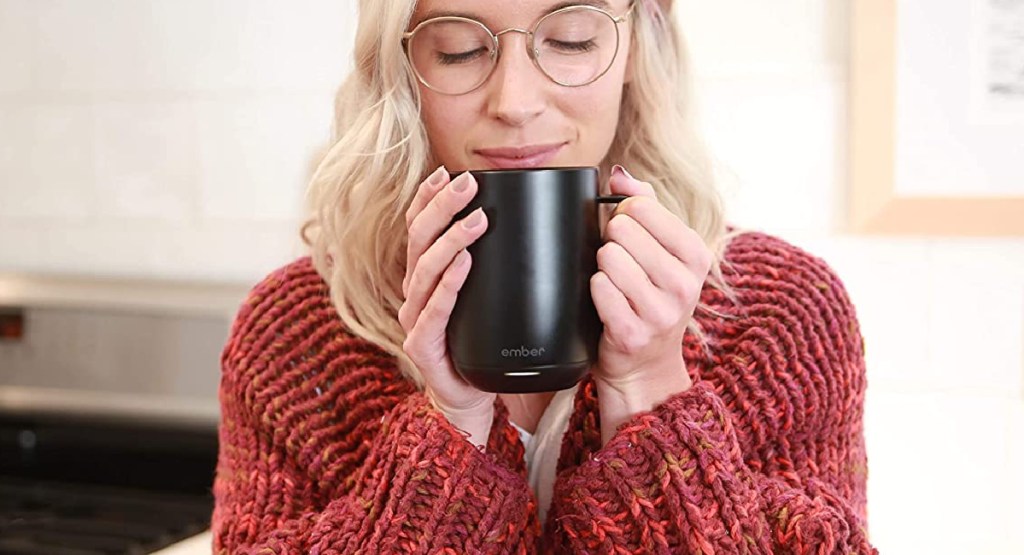 Frau hält Glut-Kaffeetasse in der Hand