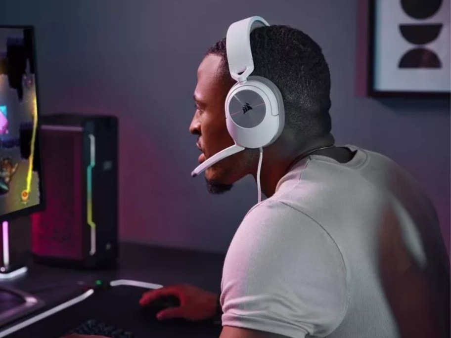man wearing a white gaming headset while playing video games