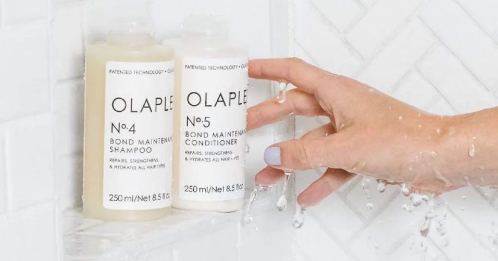 Olaplex No.4 Bond Maintenance Shampoo 8.5 oz & No.5 Conditioner 8.5 oz - COMBO Pack shown in shower with woman's hand reaching for them