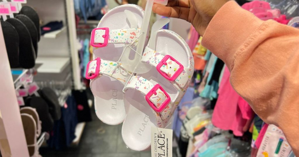 The Children's Place Girls Buckle Slides Splatter White in woman's hand in store