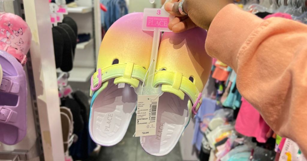 The Children's Place Girls Rainbow Clogs in woman's hand in store