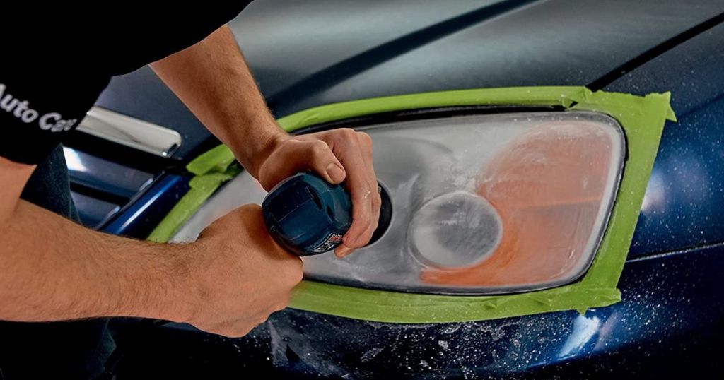 man using drill to sand headlight